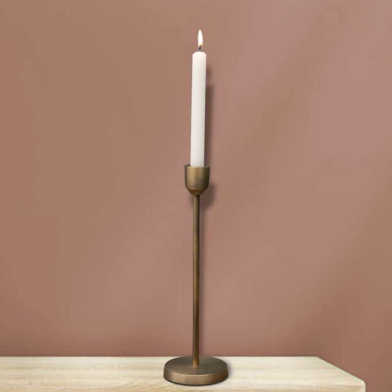 Chandelier doré de 30,5 cm avec chandelle blanche devant un mur ocre.