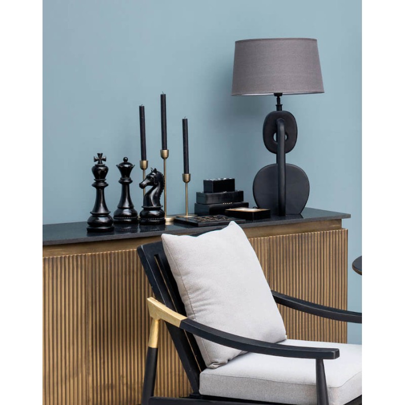 Composition de bougeoirs dorés antiques sur un meuble de salon design.