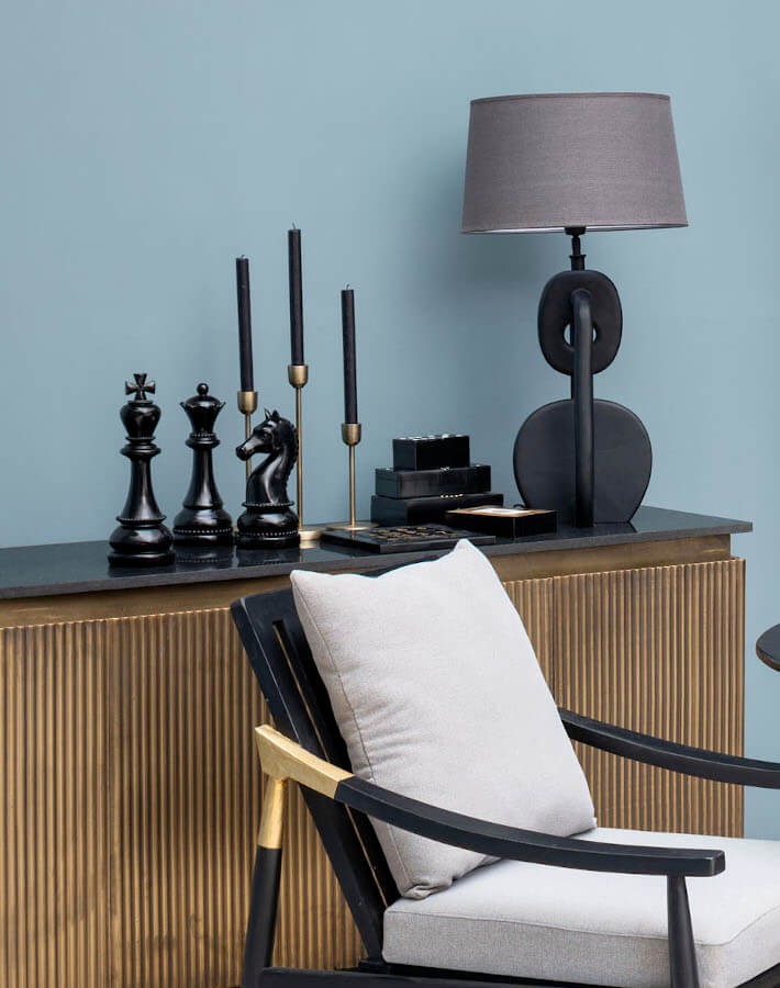 Composition de bougeoirs dorés antiques sur un meuble de salon design.