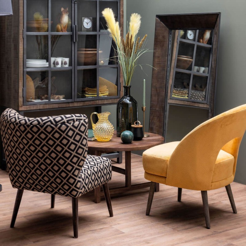 Ambiance d'intérieur chic avec bougeoir doré antique et fauteuils en velours.