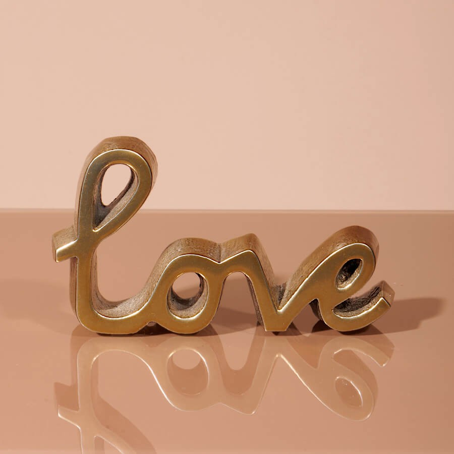 Statuette romantique en aluminium vue de dessus sur fond brillant.