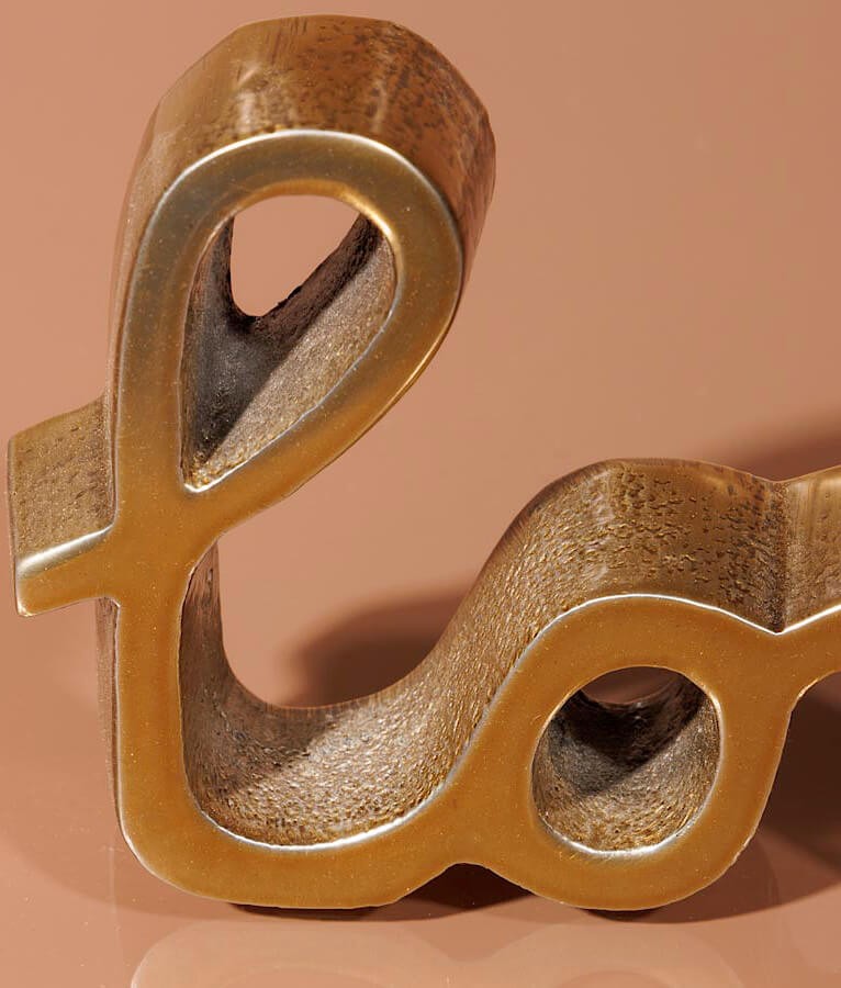 Zoom sur la texture de l'aluminium patiné or de la statuette love.