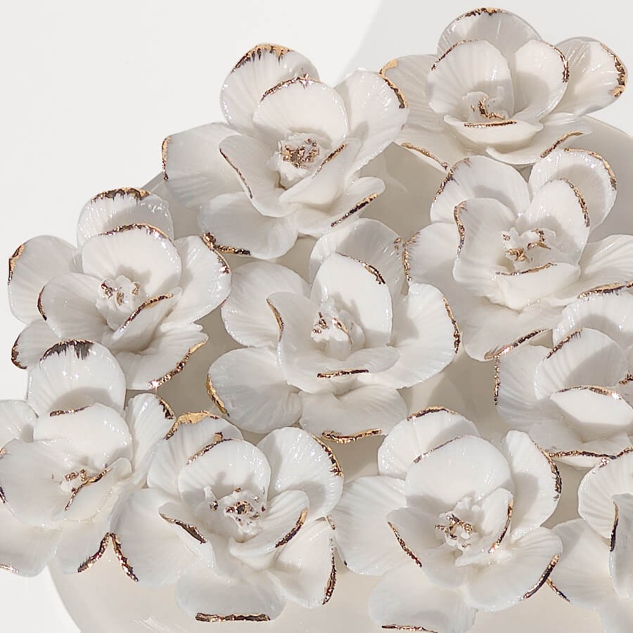 Détail des fleurs blanches aux pétales soulignés d'or.