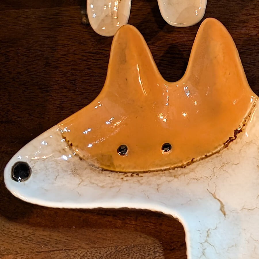 Détail de la tête stylisée du Corgi et de l'émaillage brillant.