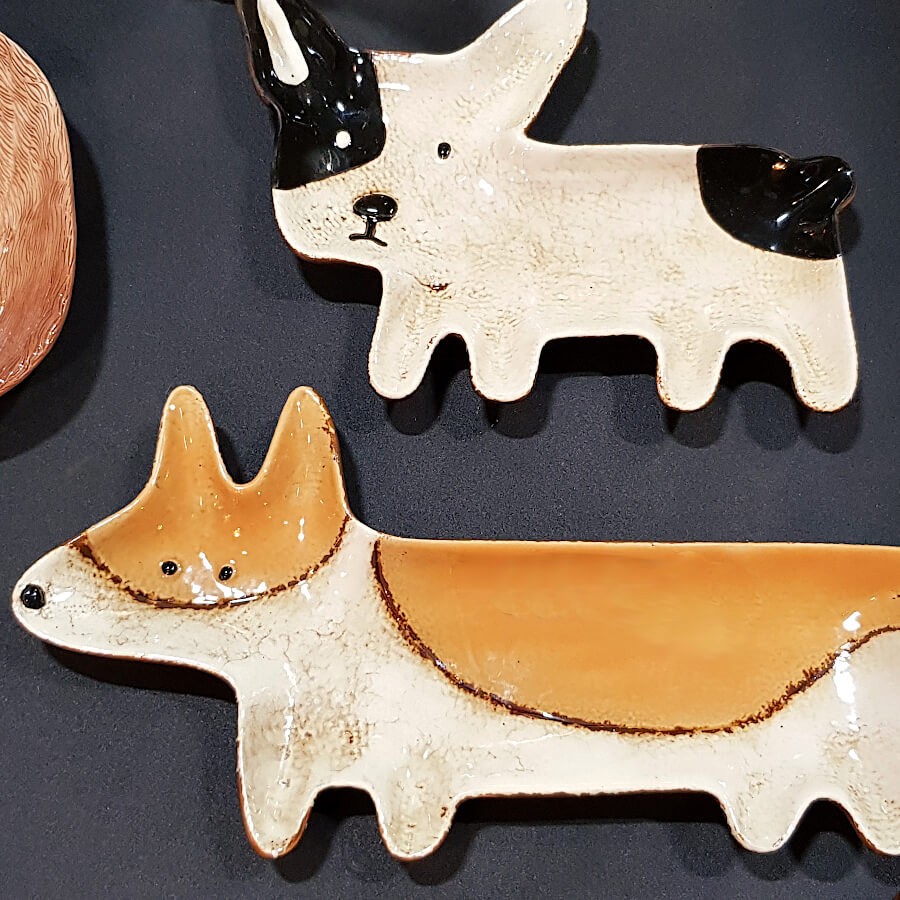 Comparatif des plats Corgi et Bouledogue sur fond sombre.