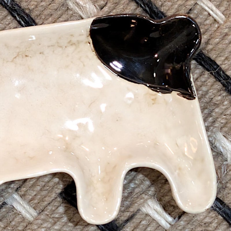 Zoom sur la finition émaillée et la queue noire du bouledogue.