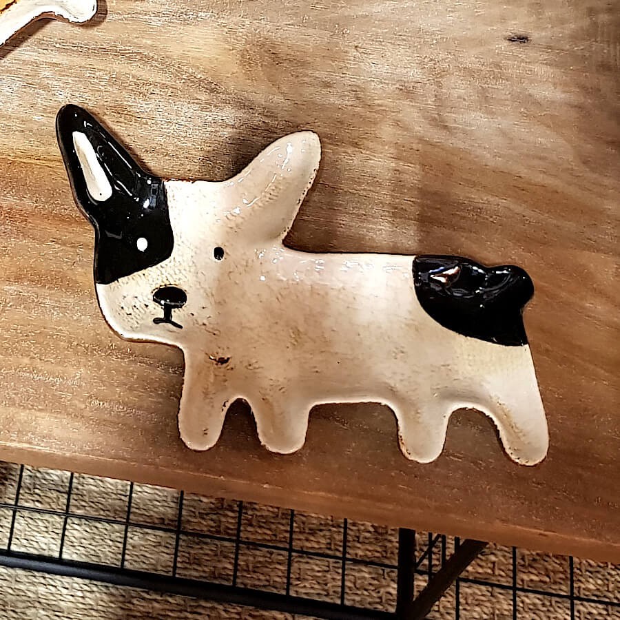 Objet décoratif canin posé sur une table desserte en bois naturel.