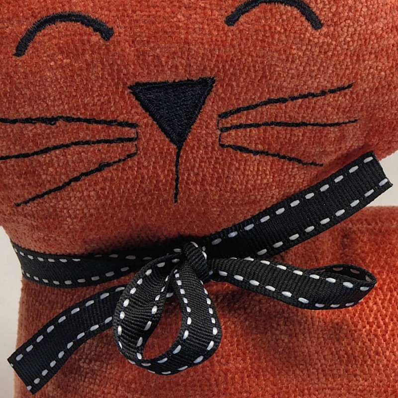 Détail de la texture du tissu et des finitions brodées.