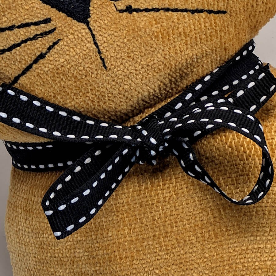 Zoom sur le ruban noir satiné à pois du chat décoratif.