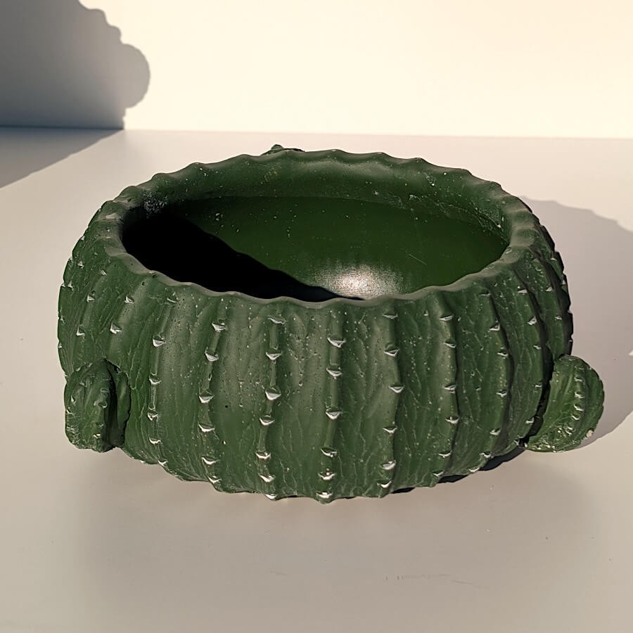 Vue de trois-quarts montrant la forme globulaire et les protubérances du porte-plante.