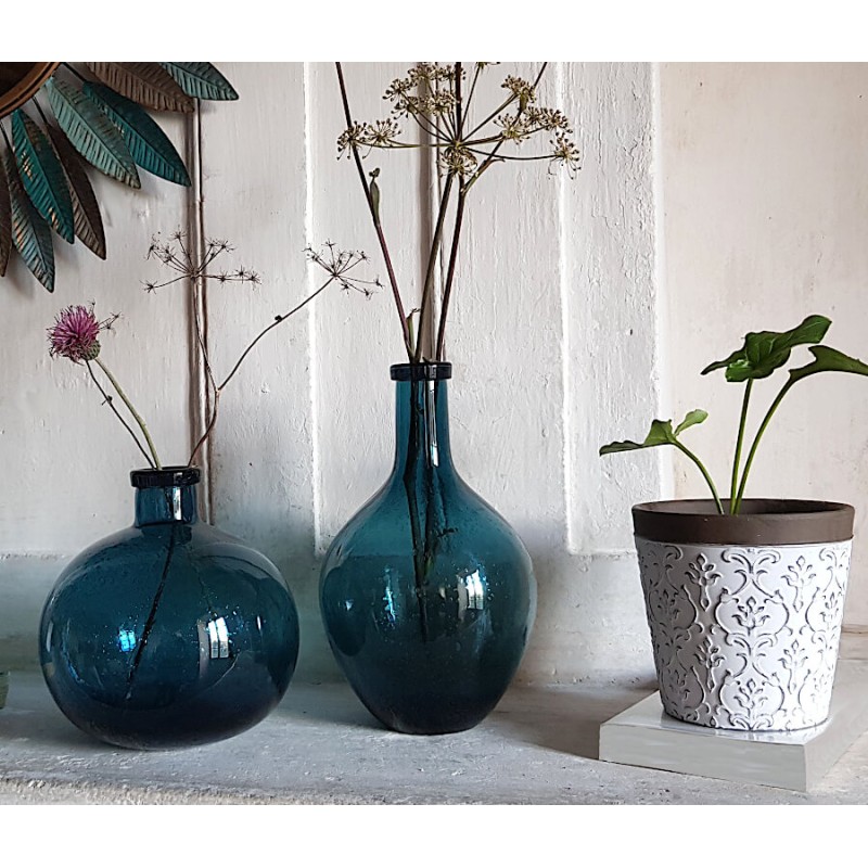 Composition avec vases bouteilles bleus et cache-pot blanc gravé de chez Deco-Delight.