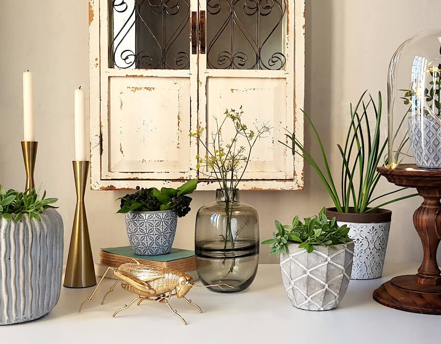 Décoration de buffet avec bougeoirs dorés, plantes et cache-pots, style de déco Campagne-chic.