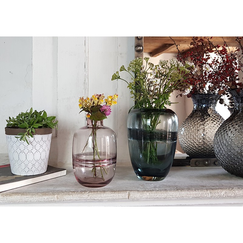 Cache-pot blanc et marron exposé sur une étagère de salon aux côtés de vases en verre coloré et d'objets déco de Deco-Delight.