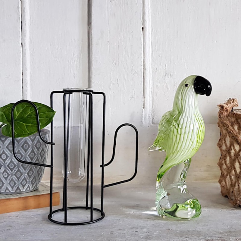 Le soliflore cactus à côté d'une statuette de perroquet vert.