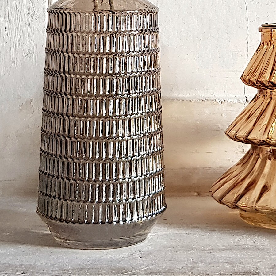 Gros plan sur les facettes en relief et les reflets du verre fumé.