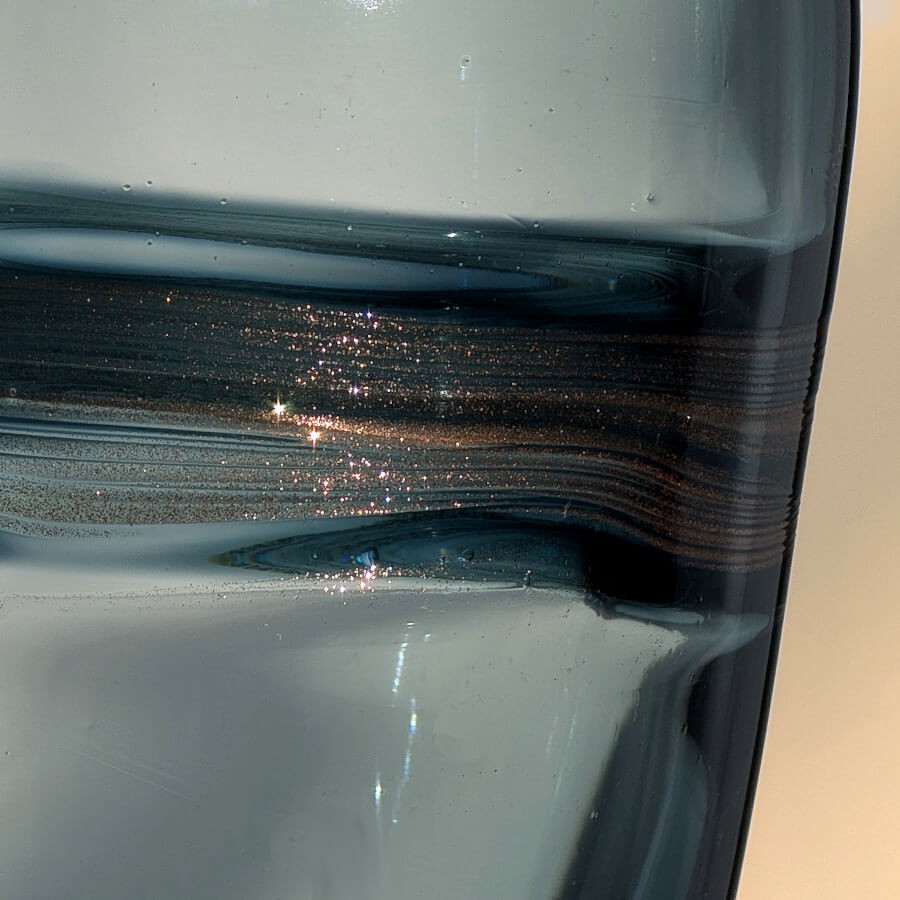 Gros plan sur les paillettes dorées incrustées dans la ceinture centrale.