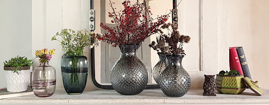 Mise en scène complète intégrant le vase pailleté sur la tablette d'une cheminée en pierre.