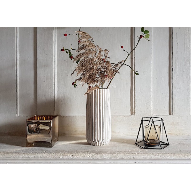 Le vase blanc-crème fleuri hauteur 25 cm sur une console aux côtés de photophores Deco-Delight.