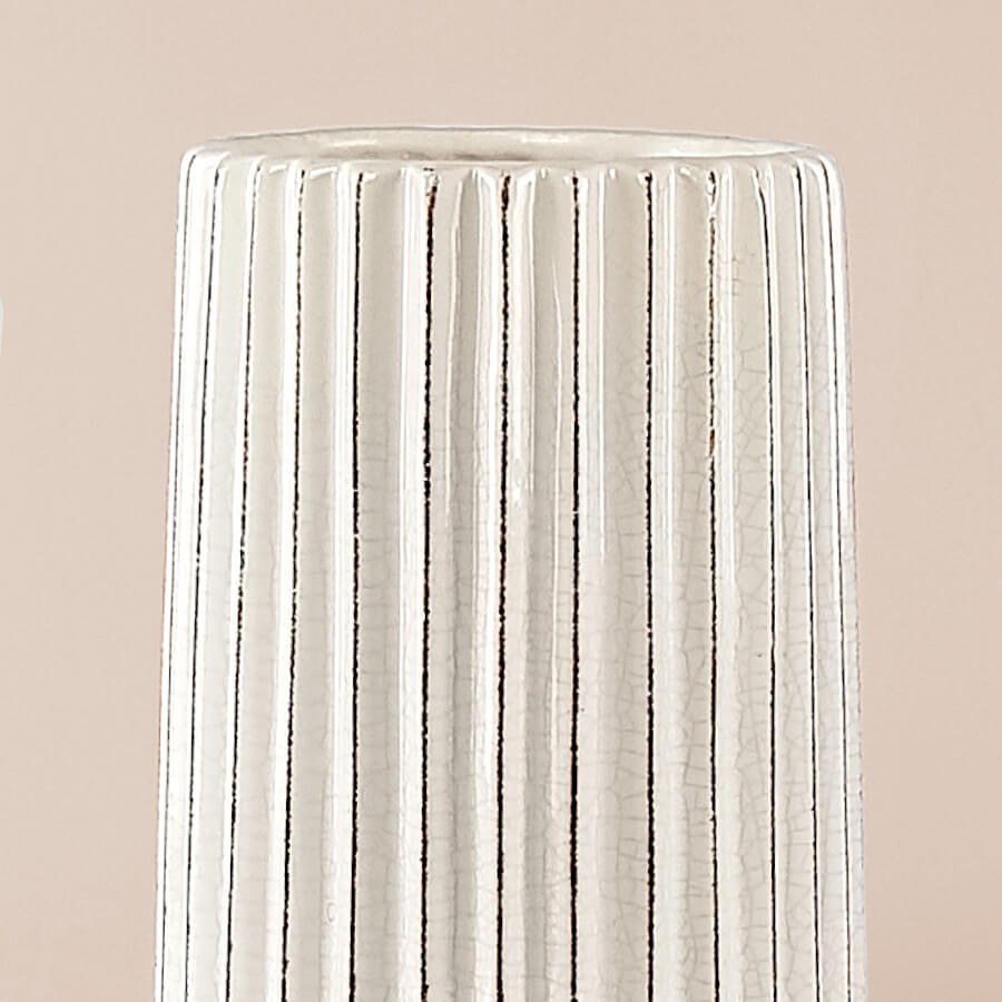 Détail de la texture et du graphisme facetté du modèle blanc sur fond uni doux.