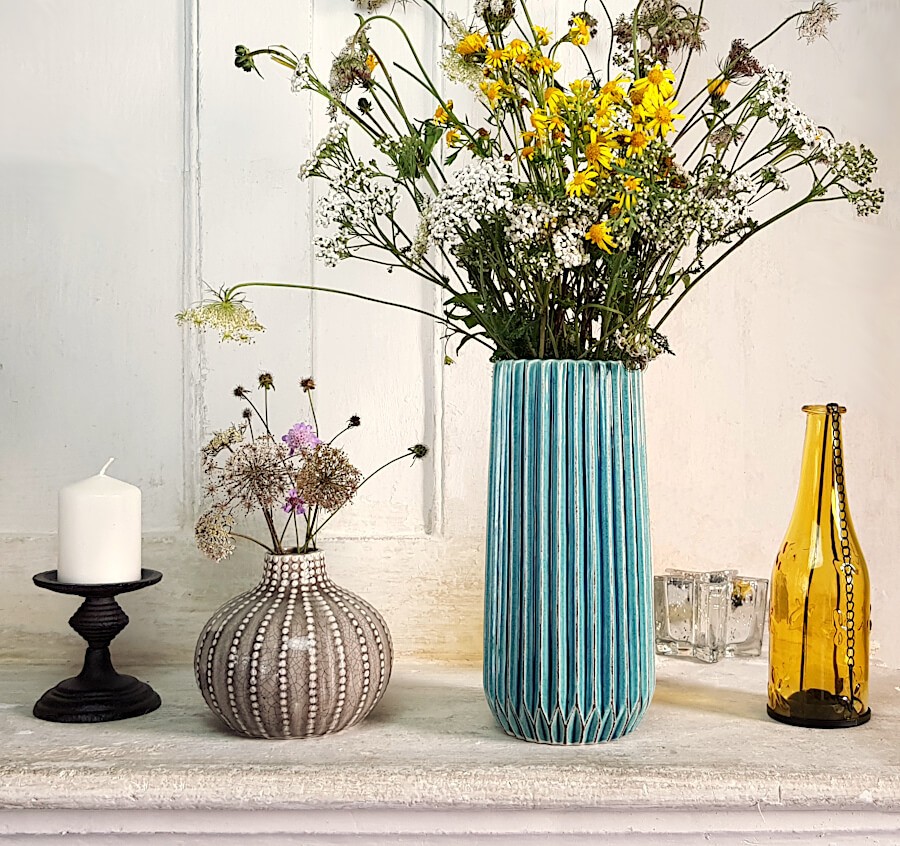 Fleurs des champ dans le vase turquoise, en joli contraste avec des accessoires jaune et gris.