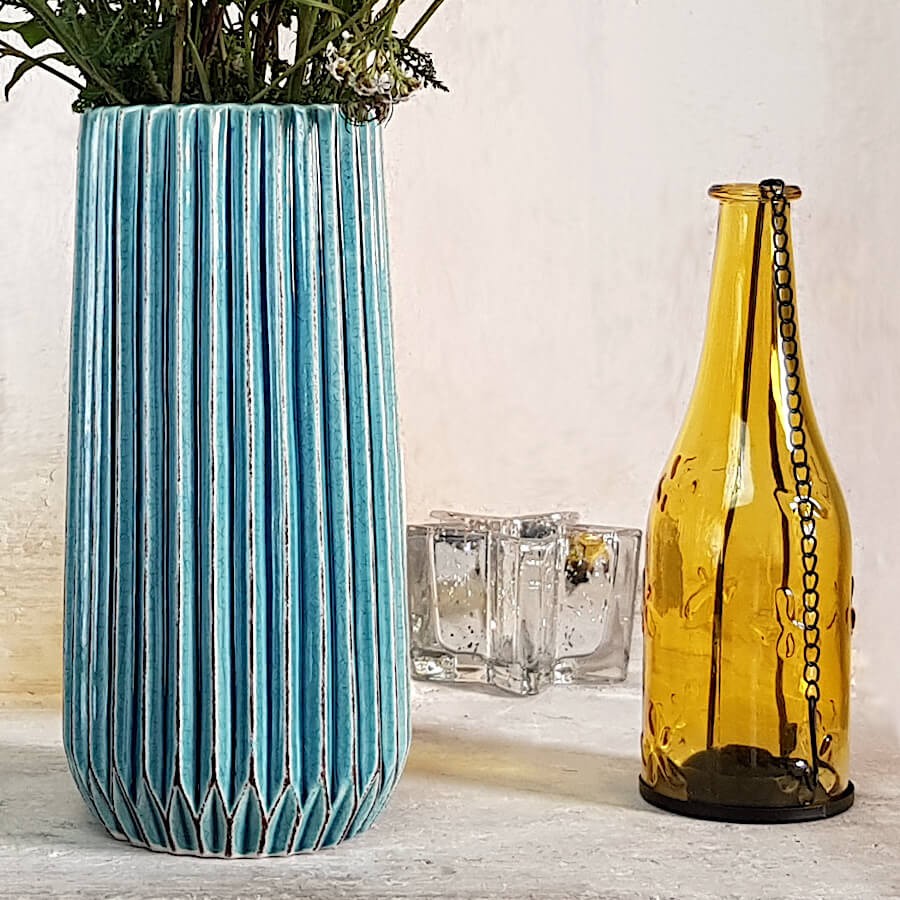 Vue rapprochée du modèle turquoise avec un photophore-bouteille jaune.