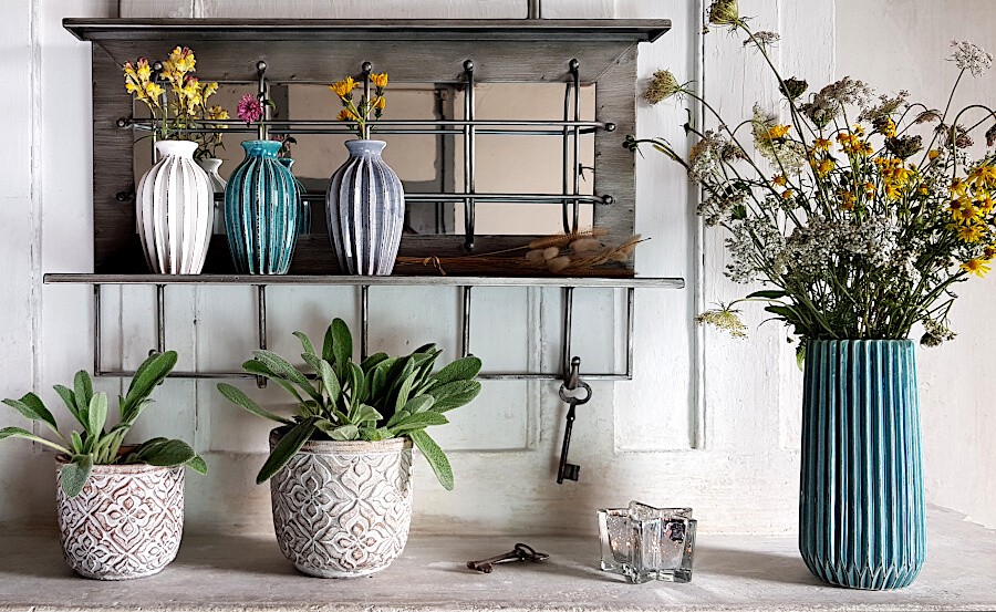 Le vase turquoise fleuri sur une étagère avec plateau et accessoires déco Deco-Delight.