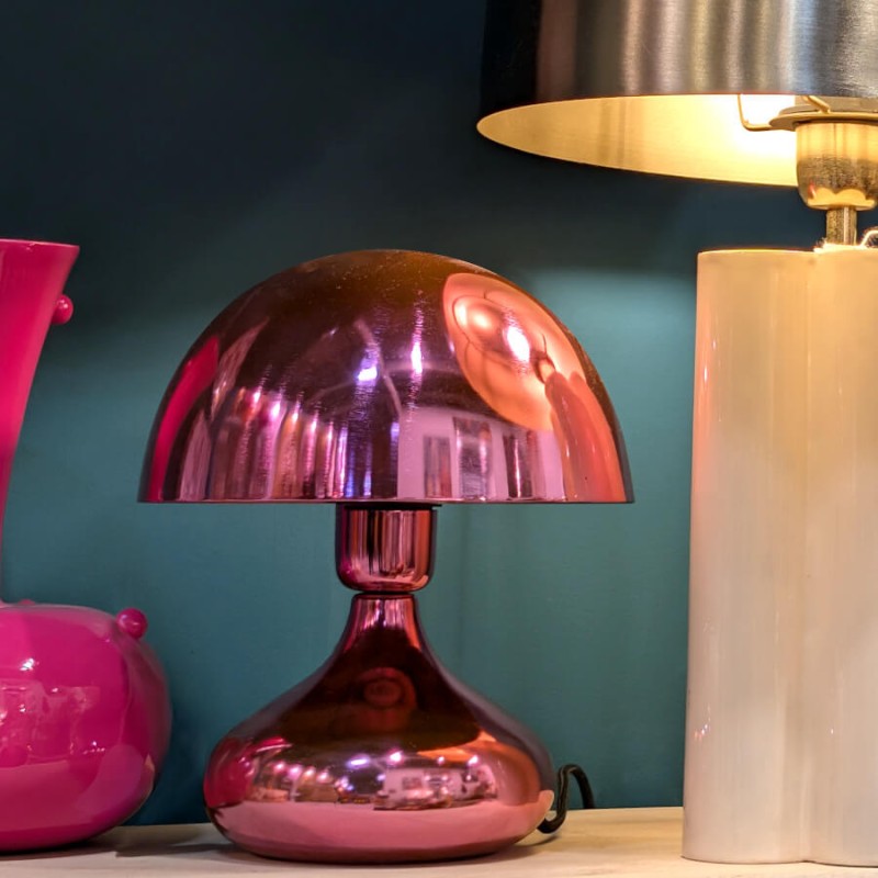 Lampe champignon rose pop sur une étagère, qui attire le regard en toutes circonstances.