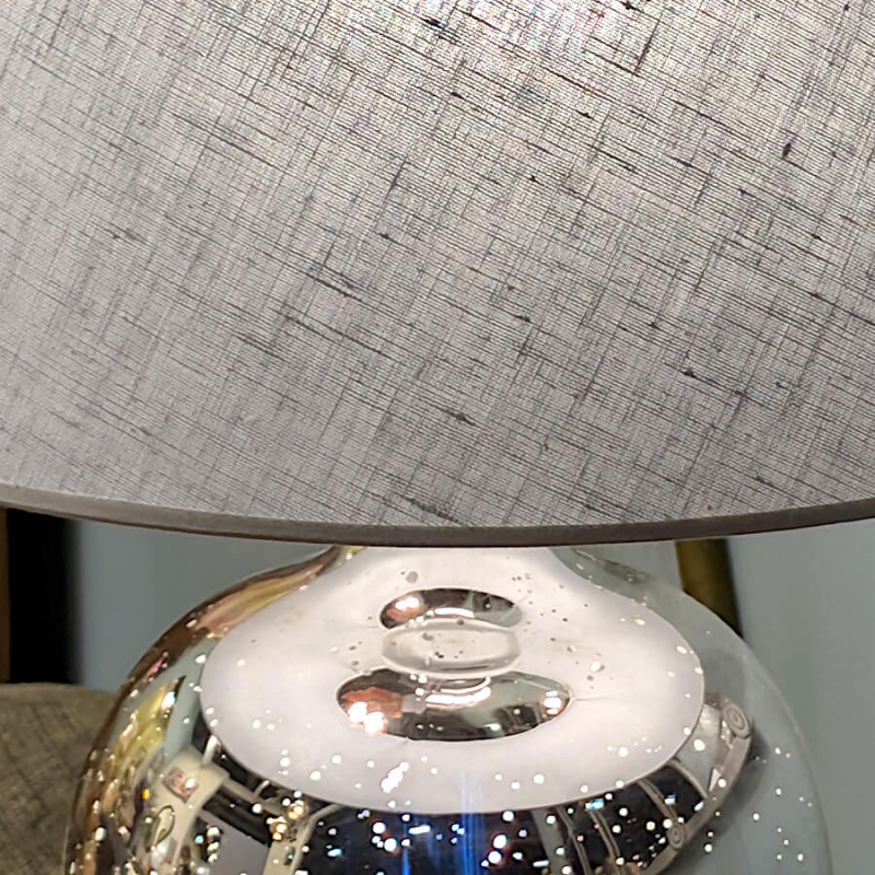 Détail de la texture du lin et du haut du pied en verre argenté.