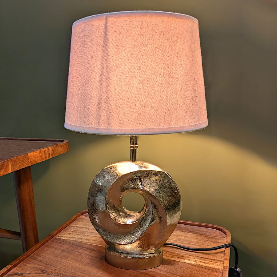 Lampe dorée Pix'Art de Deco-Delight, mise en scène sur une console en bois.