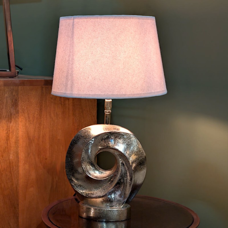 Vue d'ensemble de la lampe allumée dans un décor d'intérieur chaleureux sur fond de mur vert sombre.