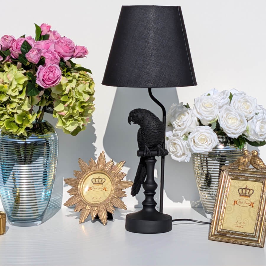 Composition décorative Deco-Delight avec fleurs, cadres et lampe perroquet.
