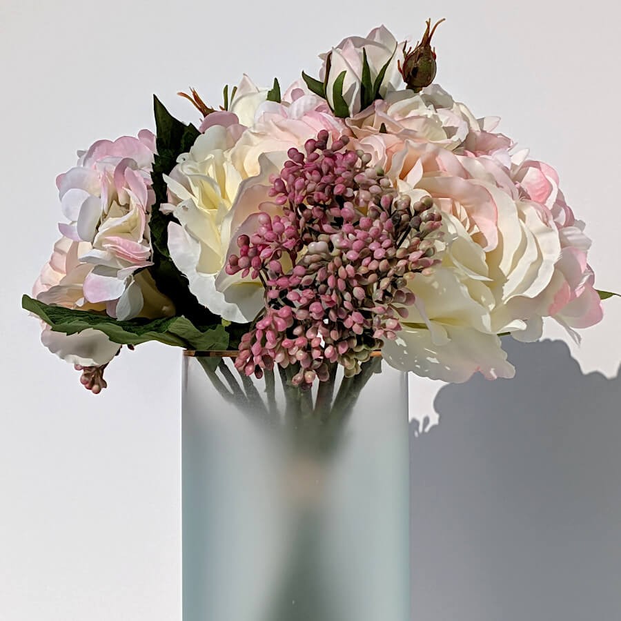 Détail d'un bouquet d'hortensias et roses blanches de la collection Deco-Delight dans le vase bleu.