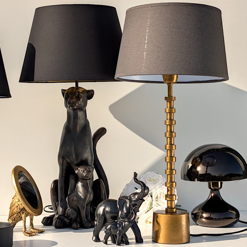 Présentation de la lampe colonne dorée au sein d'une collection d'objets déco noirs et dorés de Deco-Delight.