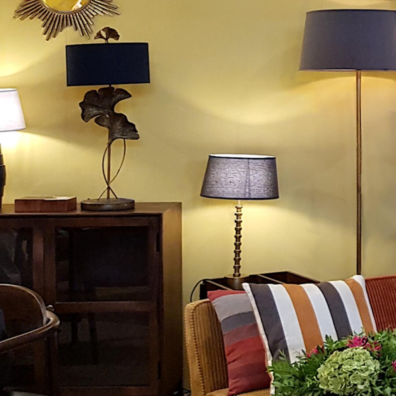 Ambiance cosy montrant la lampe crénelée, intégrée dans un salon moderne à côté d'un fauteuil.