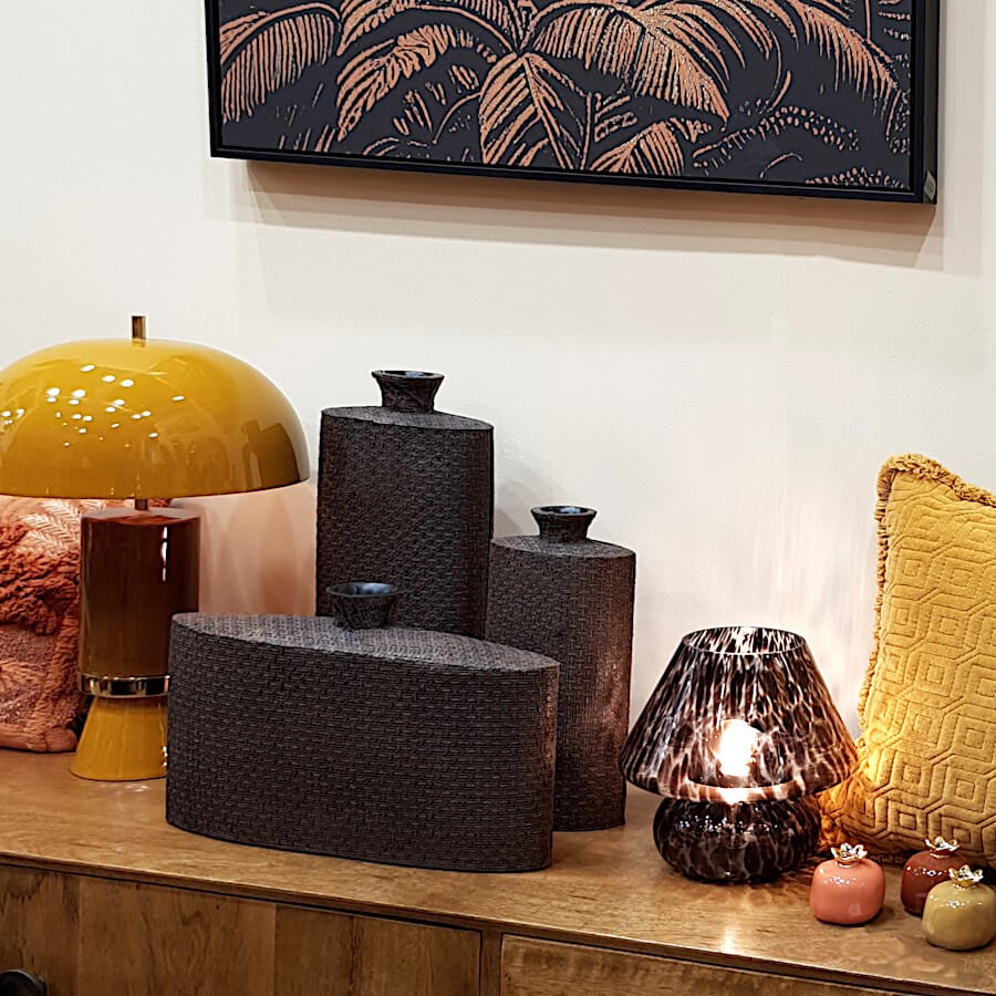 Mise en scène finale de la lampe dans une bibliothèque avec vases et objets déco.