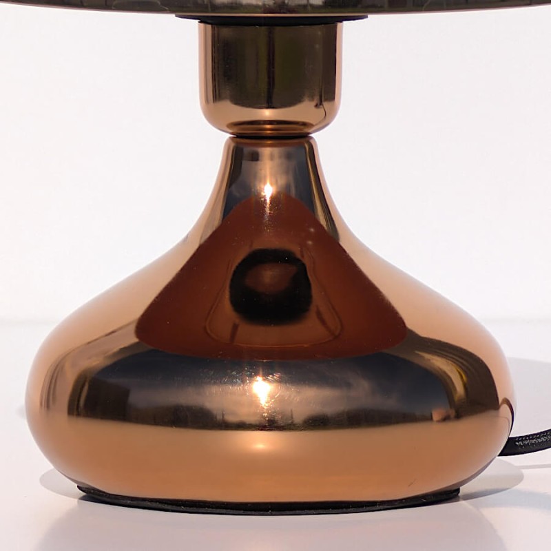 Gros plan sur le pied évasé et le fini chromé impeccable du métal cuivre.