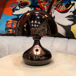 Détail des reflets sur le dôme noir chromé de la lampe champignon dans un intérieur moderne.