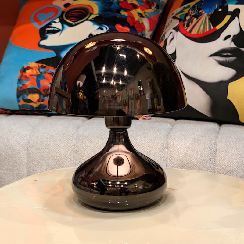 Détail des reflets sur le dôme noir chromé de la lampe champignon dans un intérieur moderne.