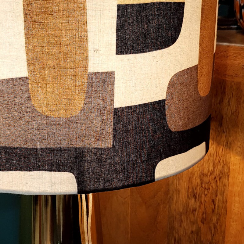 Focus sur l'abat-jour en coton montrant le détail du tissage et le tombé du motif géométrique gris-bleu et ocre.
