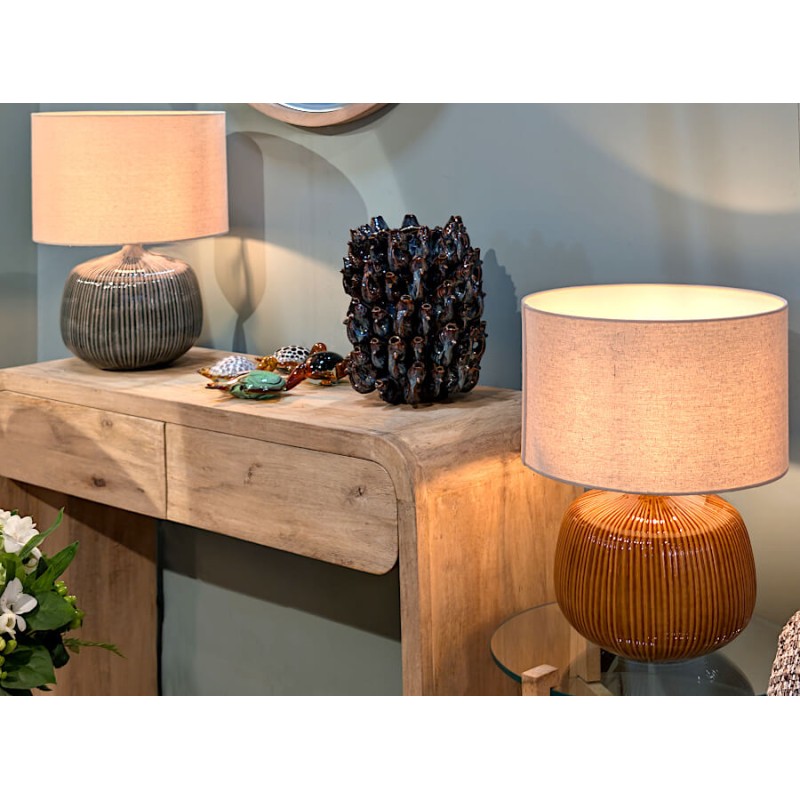 La lampe ocre mise en valeur sur une console d'entrée, créant un point lumineux chaleureux.