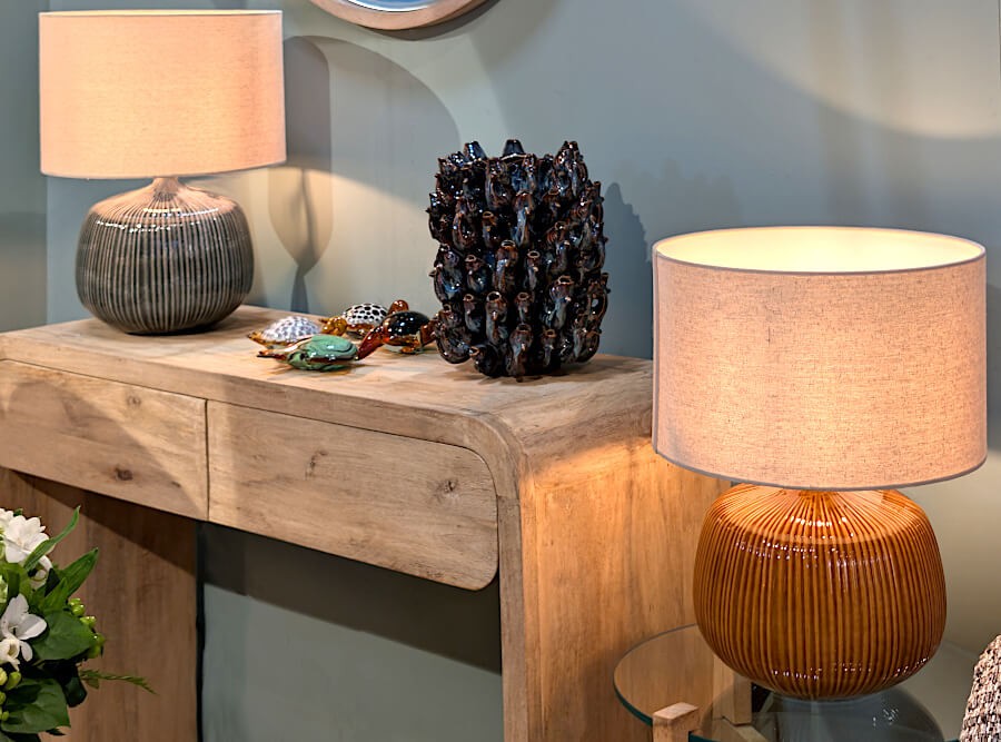 La lampe ocre mise en valeur sur une console d'entrée, créant un point lumineux chaleureux.