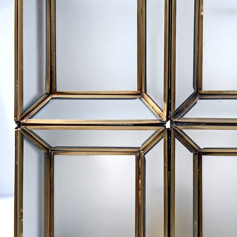 Zoom sur le détail des finitions du métal doré et des parois en verre dépoli.