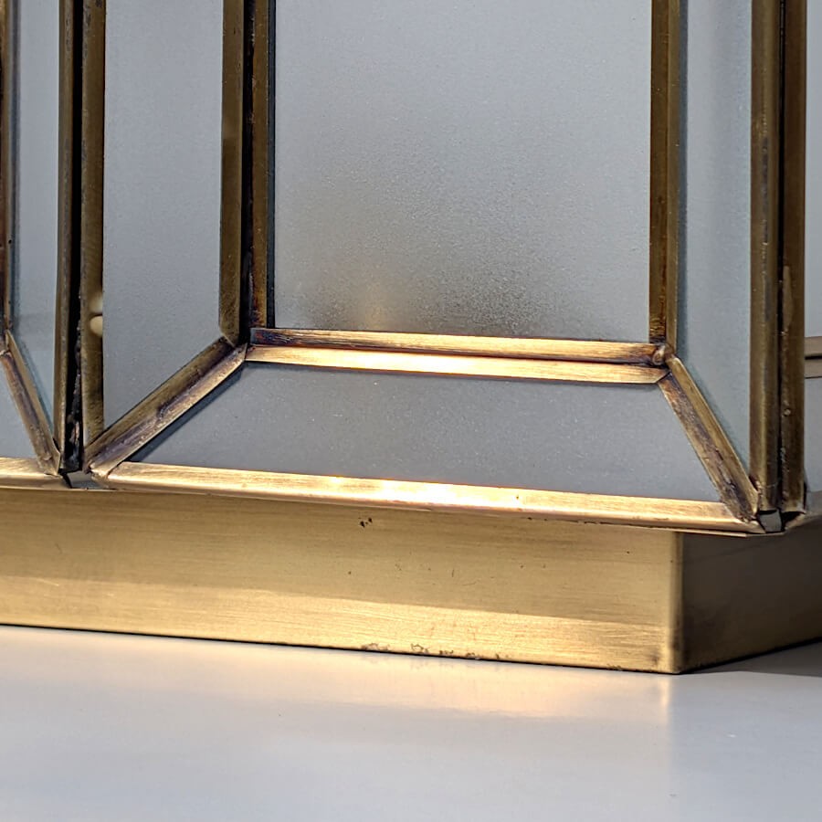 Focus sur la base solide en métal doré brillant assurant une stabilité parfaite du luminaire.