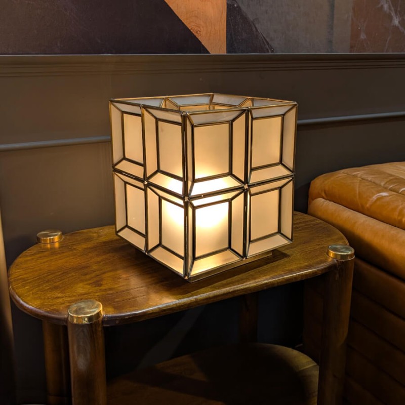 Ambiance nocturne : la lampe sur un guéridon, créant un jeu d'ombres géométriques.