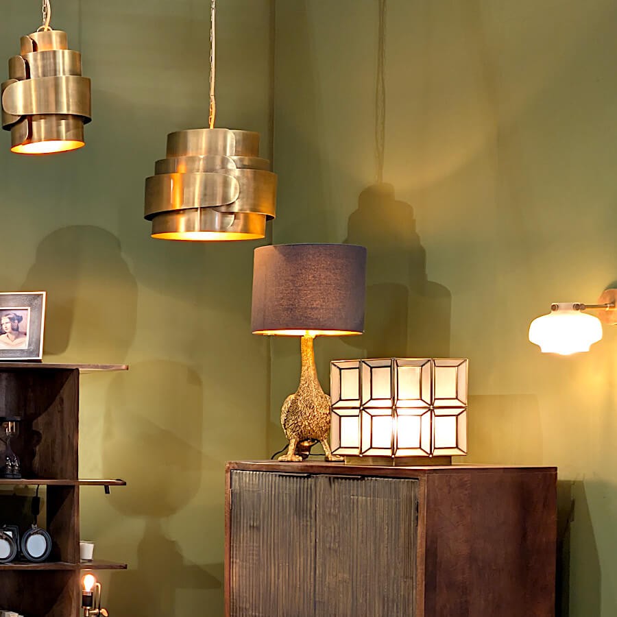 Mise en scène décorative de la lampe à côté d'une applique et de suspensions luminaires design.