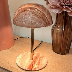 Ambiance chaleureuse : la lampe minérale allumée sur un meuble en bois clair.