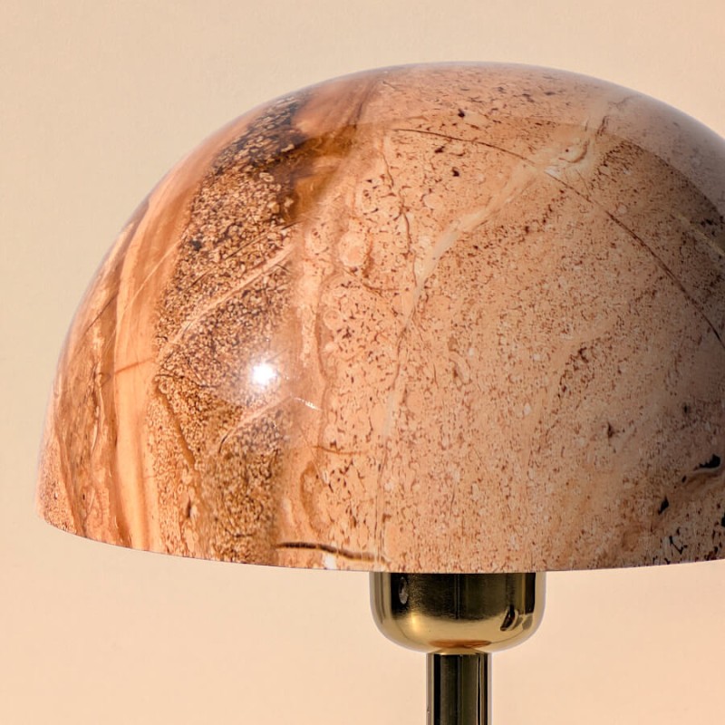 Zoom sur le dôme en pierre polie révélant les veines naturelles et les nuances brunes.