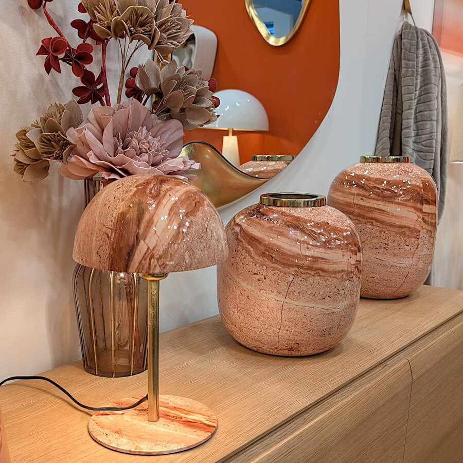 Mise en scène déco : la lampe entourée de vases artisanaux aux tons terreux et naturels.