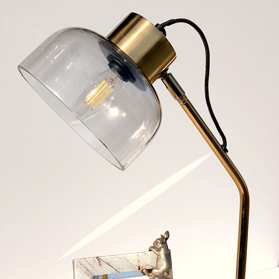 Zoom sur la tête de lampe inclinable et le détail du verre gris translucide.