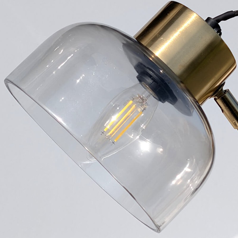 Focus sur l'ampoule E14 visible à travers l'abat-jour en verre fumé.